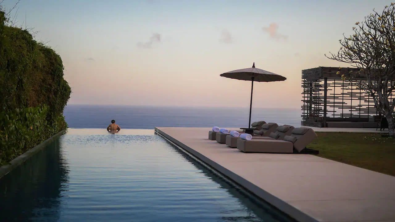 Alila Uluwatu — the infinity pool and clifftop cabana at dusk · Uluwatu, Indonesia