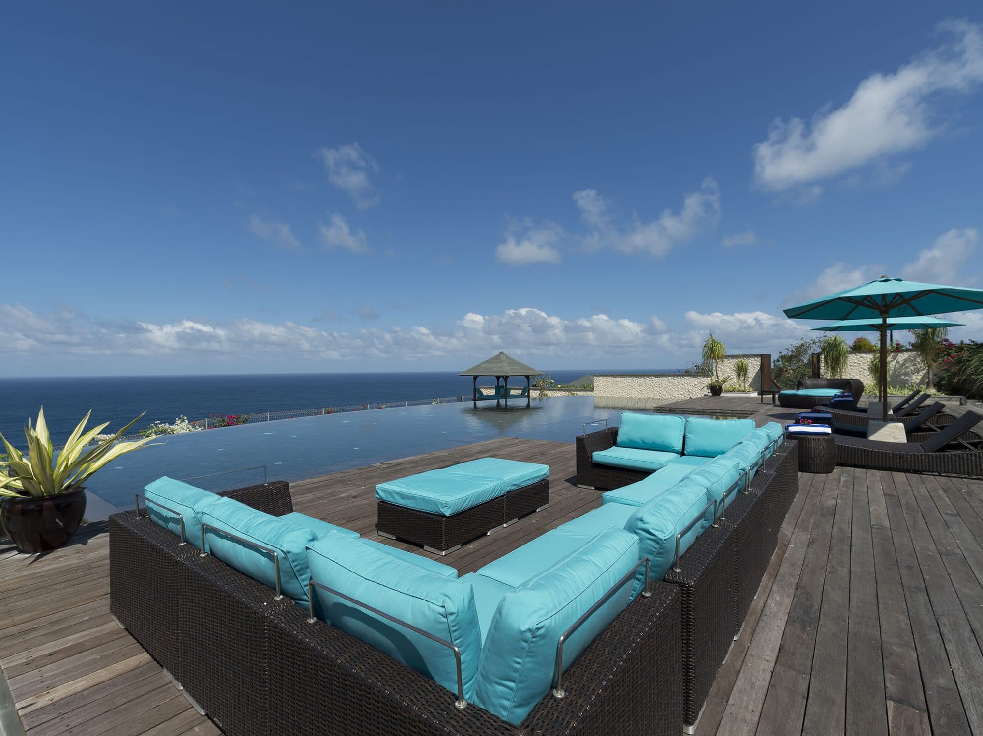 The Pala — turquoise sofas on the deck above the ocean · Bali, Indonesia