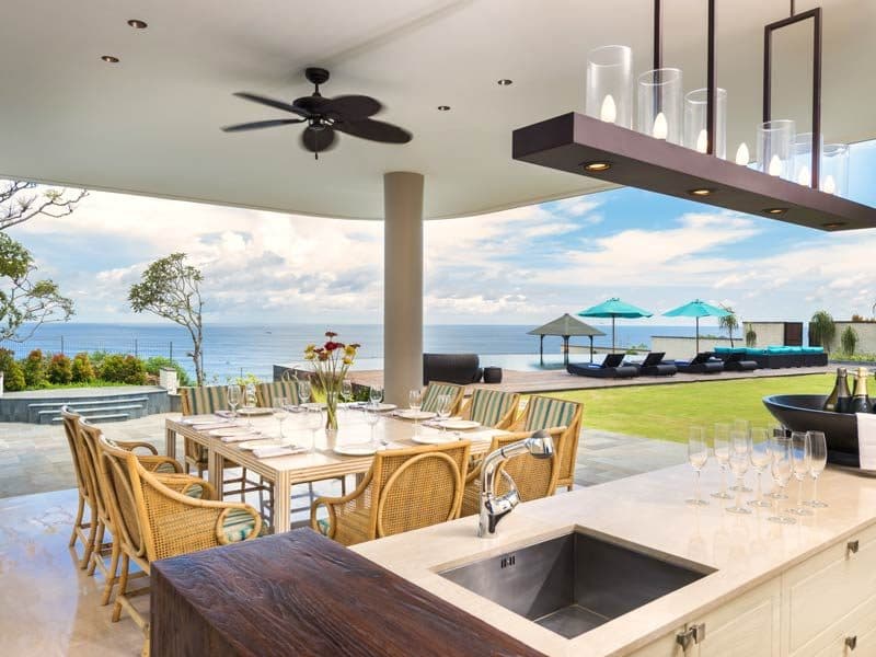 The Pala — an open kitchen and dining table with an ocean view · Bali, Indonesia