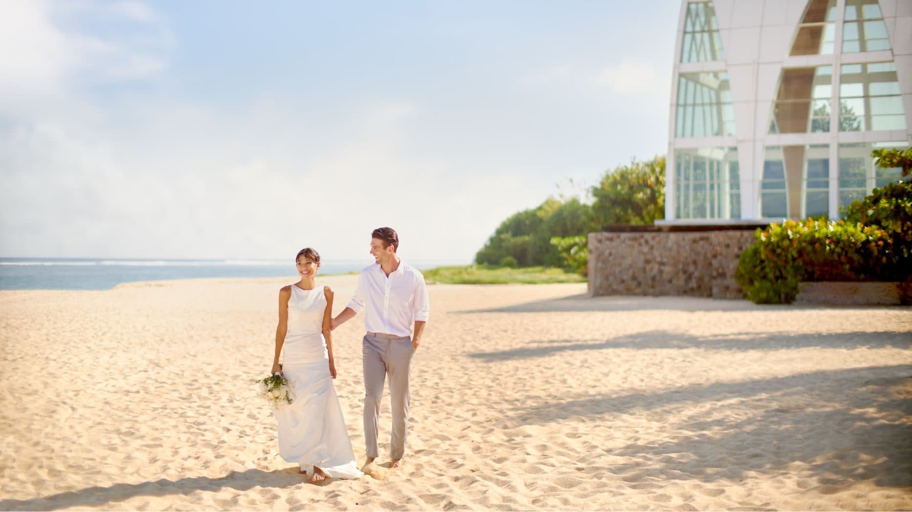 The Ritz Carlton Bali — a couple walking on the beach beside the chapel · Nusa Dua, Indonesia