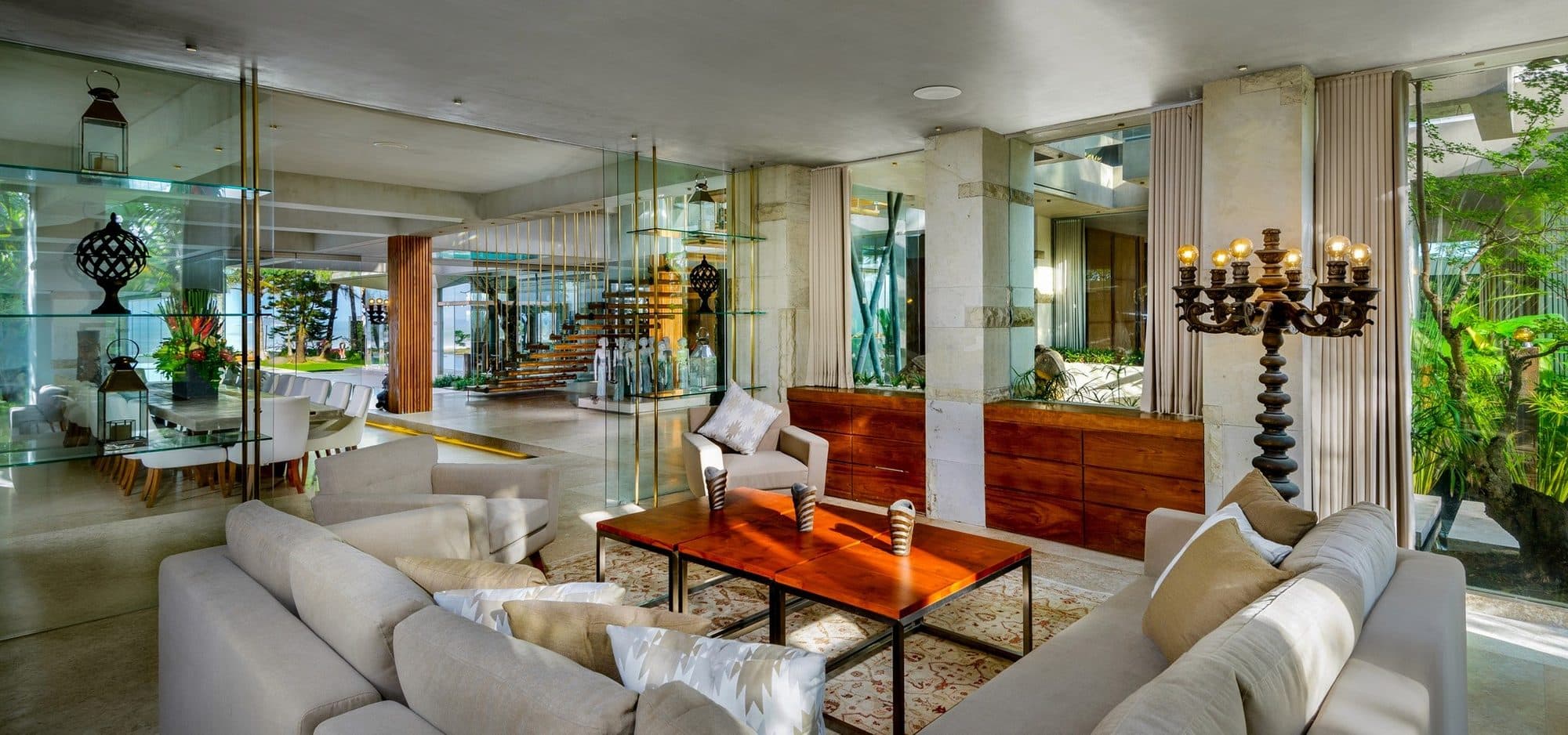 Villa Vedas — a living room with glass walls and pale sofas · Bali, Indonesia