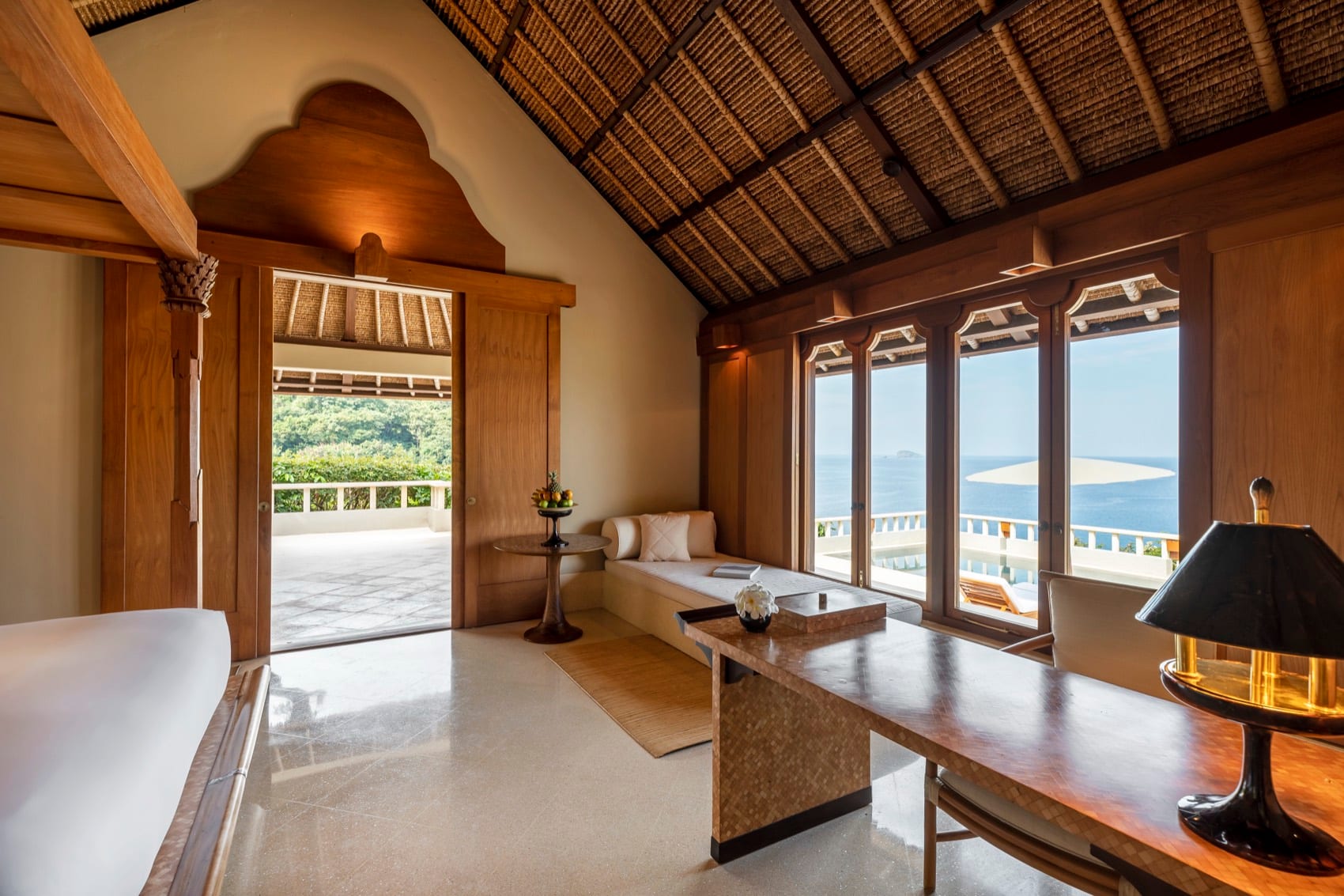 Inside an Amankila pavilion with carved wood and a sea view