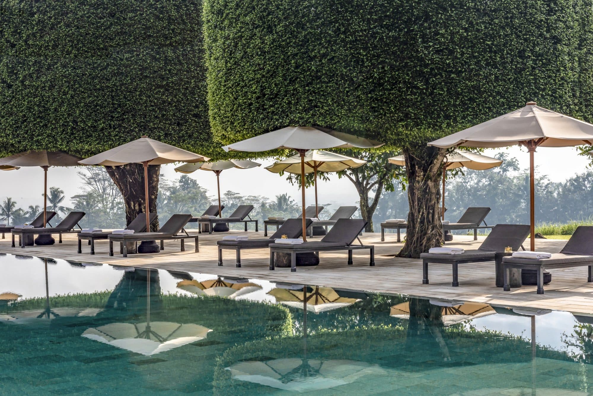 Amanjiwo — loungers and parasols along the pool · Yogyakarta, Indonesia