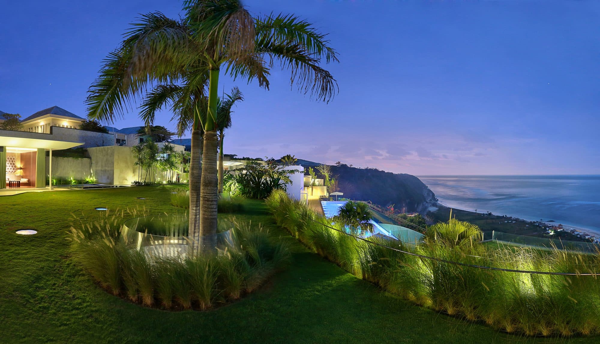 Latitude — the villa's garden and palm at dusk above the ocean · Ungasan, Indonesia