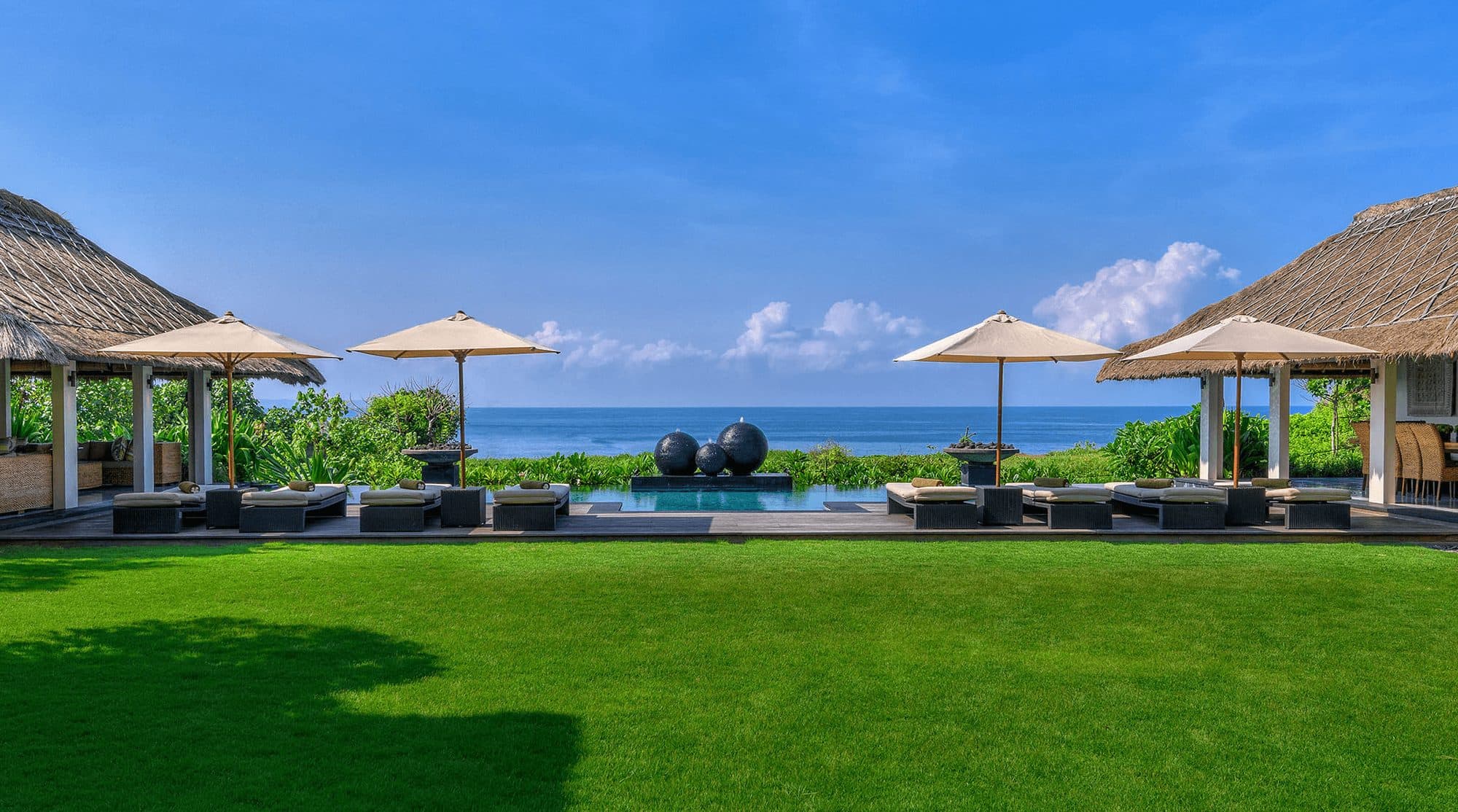 Seseh Beach Villas — the lawn, pool and parasols above the beach · Seseh, Indonesia