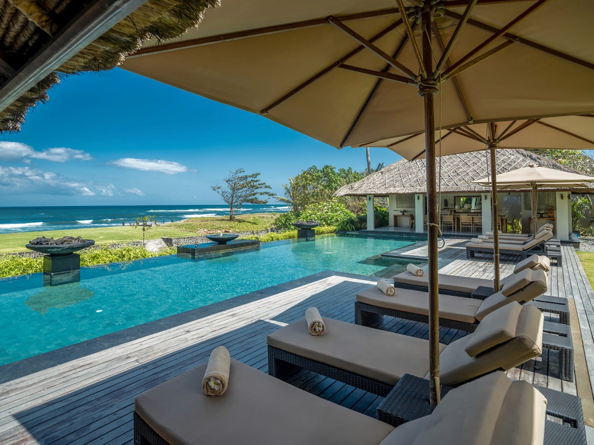 Seseh Beach Villas — loungers under parasols on the pool deck · Seseh, Indonesia