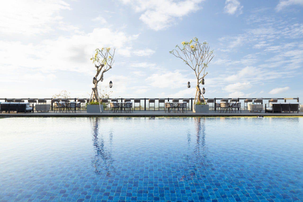 The Tulou Bali — the rooftop pool and its frangipani trees · Jimbaran, Indonesia