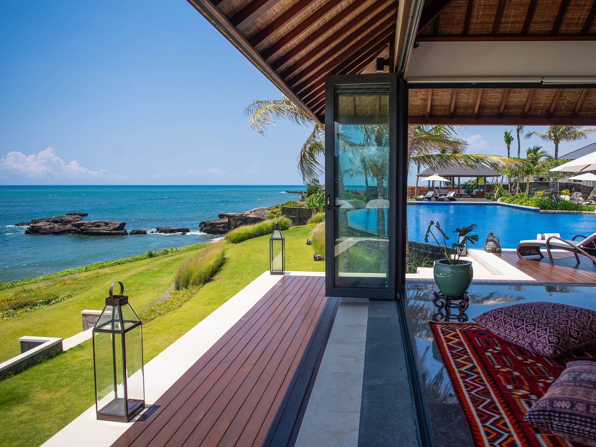 Tirtha Bayu Estate — a terrace with lanterns opening to the pool and sea · Seseh, Indonesia