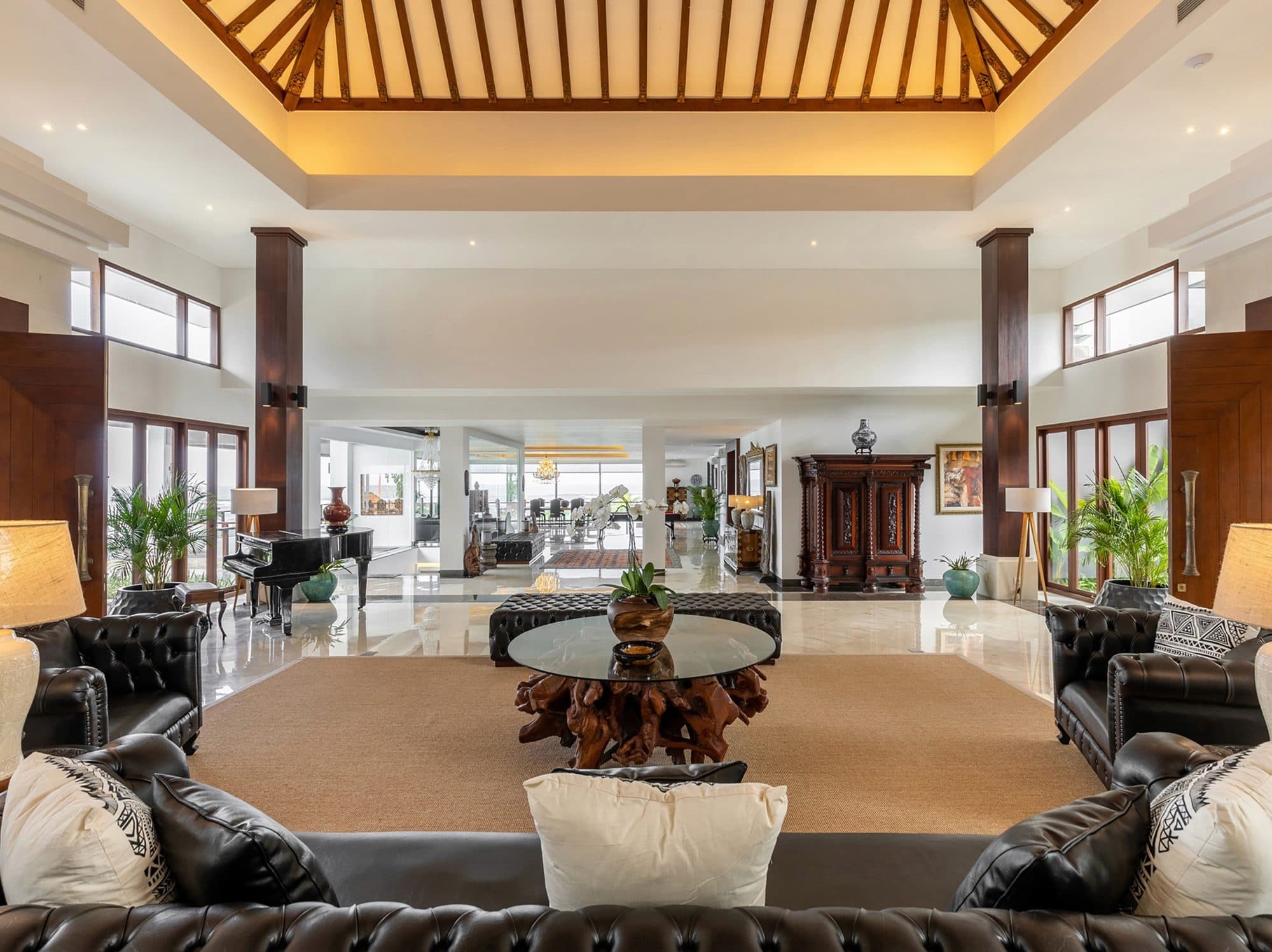 Tirtha Bayu Estate — a living hall with leather sofas and a timber ceiling · Seseh, Indonesia