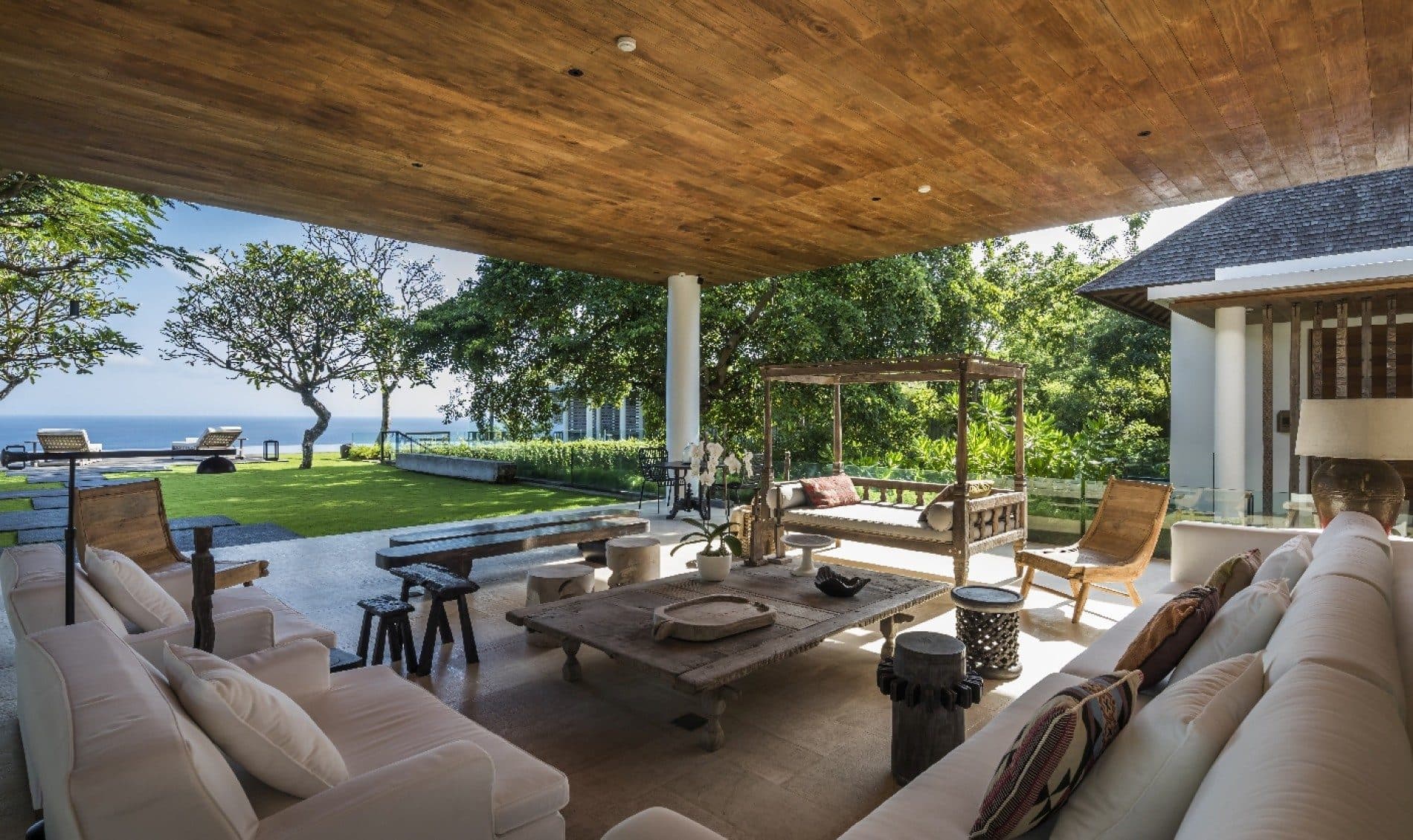 Uluwatu Estate — an open living pavilion with sofas, the lawn beyond · Uluwatu, Indonesia