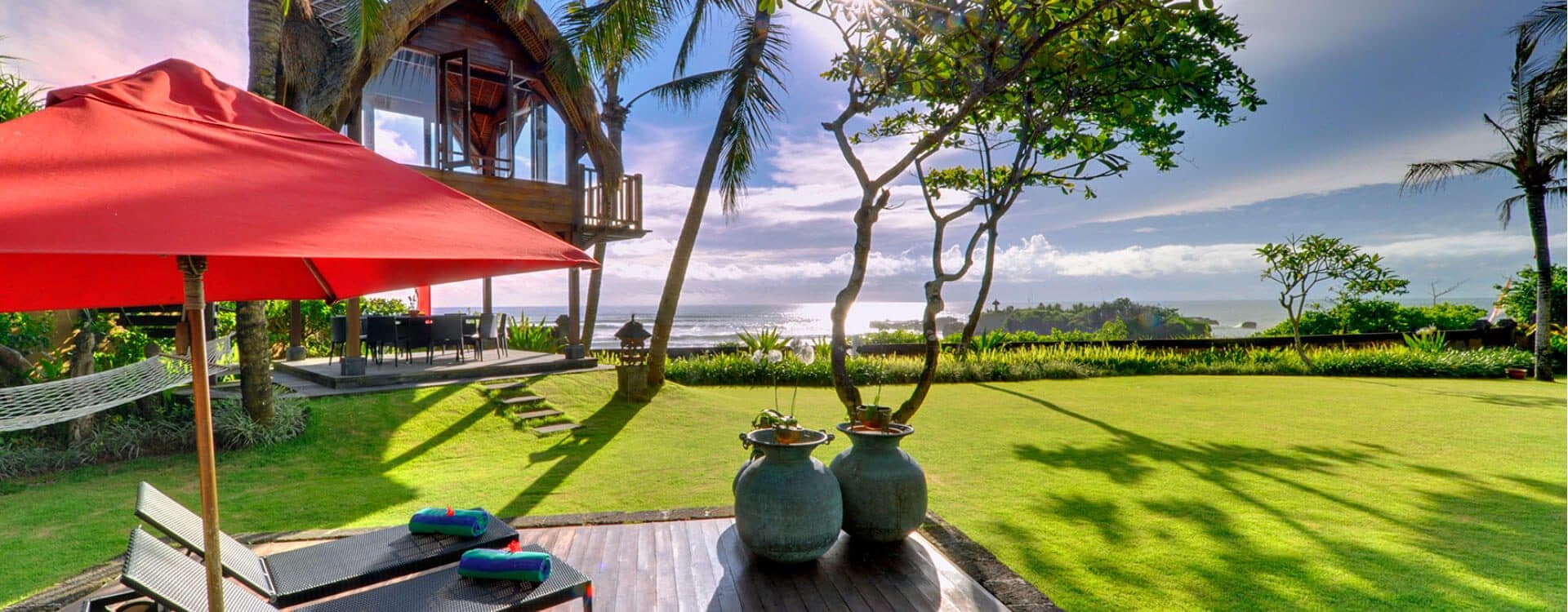 Villa Maridadi — the lawn and a red parasol, the sea beyond · Cemagi, Indonesia