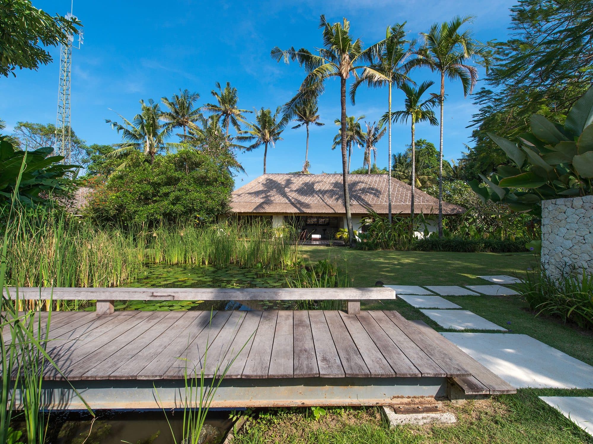 Villa Samadhana — a wooden deck across the water garden · Ketewel, Indonesia